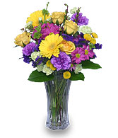 Purple carnations compliment gerberas, roses & other flowers in vase.