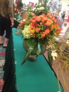 Peach and orange is mixed with different shades of green to create a beautiful and unique flower arrangement.