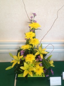Yellow floral design featuring lilies and chrysanthemums.