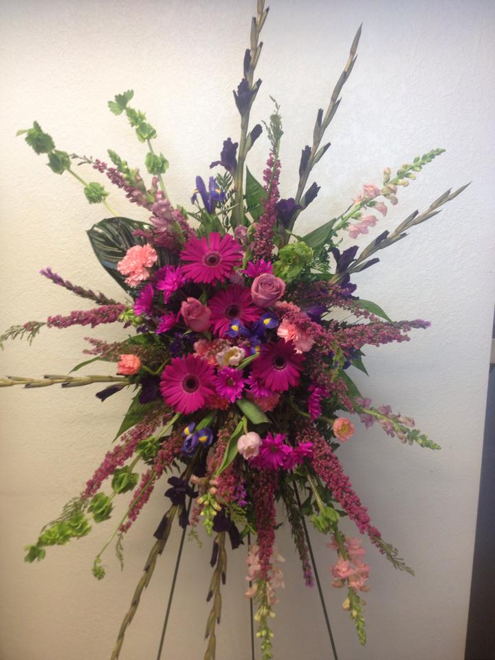 A standing spray bursting with pink from A New Beginning Florist in Moore, OK